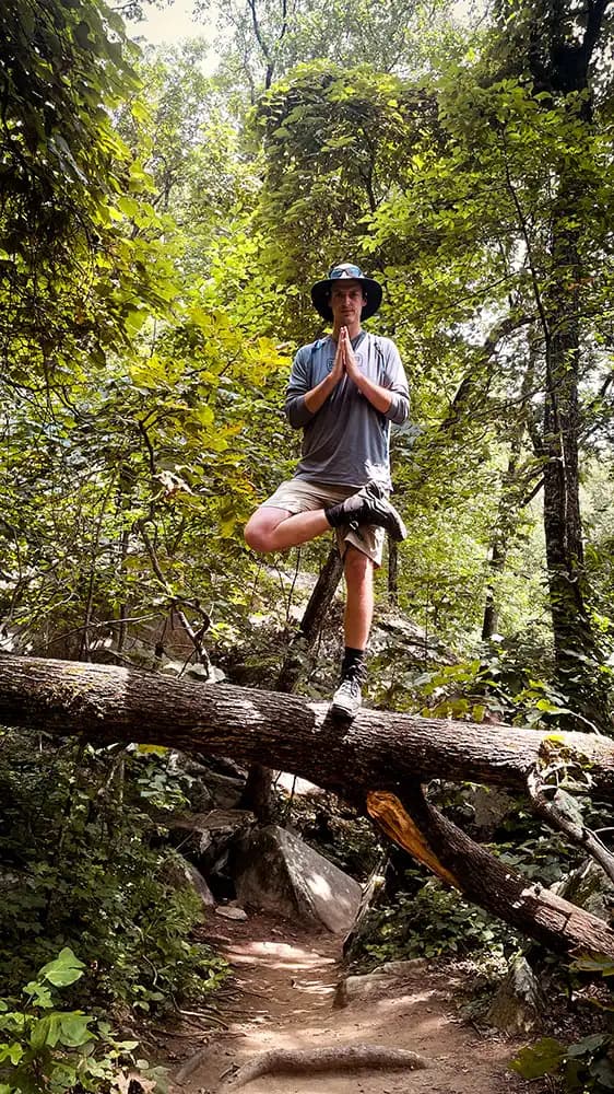 Chip Elder doing Tree Pose on a fallen tree